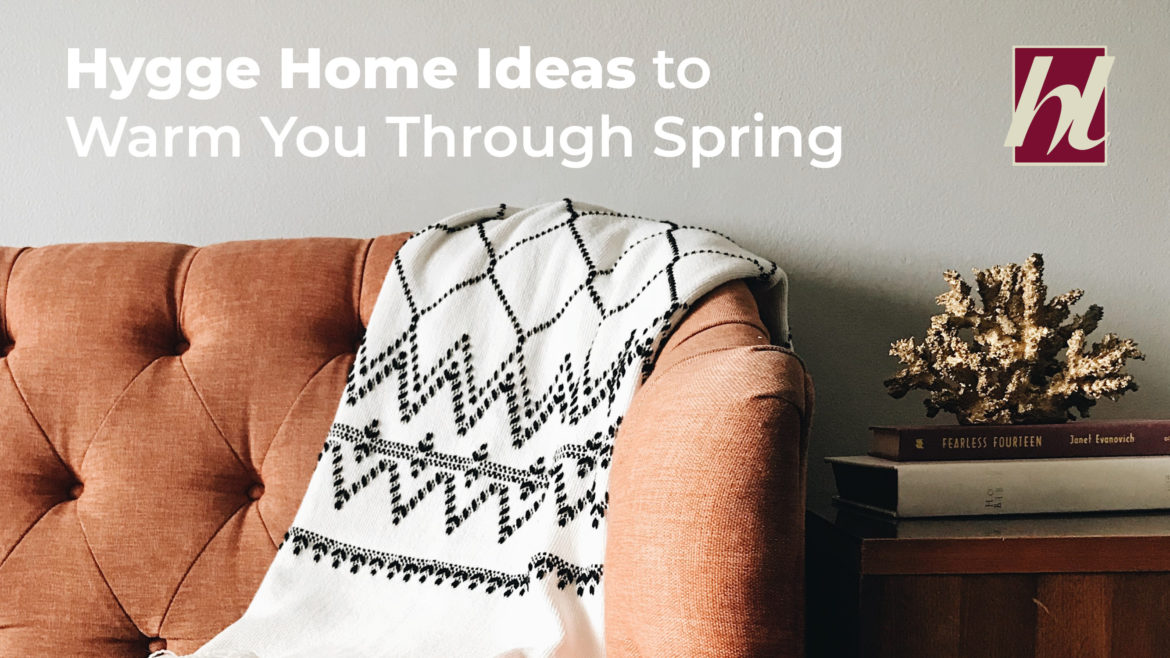 A couch with a throw blanket and text Hygge Home Ideas to Warm You Through Spring